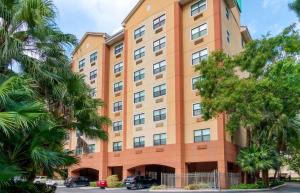 迈阿密Extended Stay America Premier Suites - Miami - Coral Gables的一座高大的橘色建筑,前面有树木