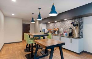 迈阿密Extended Stay America Premier Suites - Miami - Coral Gables的一间厨房,内设两张桌子和椅子