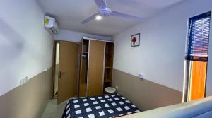 库马西Wisdom Villa的客房设有一张床和一个吊扇。