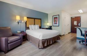 拉姆西 美国长居酒店 - 拉姆齐 - 上鞍河的配有一张床和一把椅子的酒店客房