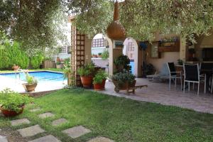 罗希姆诺Olive Villa Crete的后院设有游泳池和种植了植物的庭院。