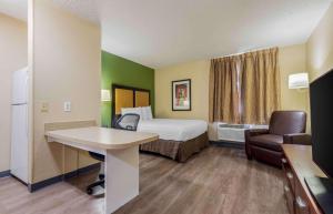 东叙拉古美国长住酒店 - 锡拉丘兹 - 德威特的小酒店客房配有一张床和一张书桌