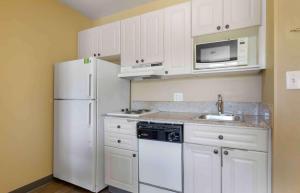 尚蒂伊美国长住酒店 - 华盛顿特区 - 尚蒂伊 - 机场的厨房配有白色橱柜和白色冰箱。