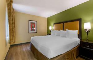 费尔法克斯阿美莉卡华盛顿特区费尔法克斯长住酒店的卧室配有白色大床和绿色墙壁