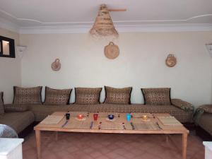 马拉喀什Riad Hostel JAD ZIAD的客厅配有沙发和桌子
