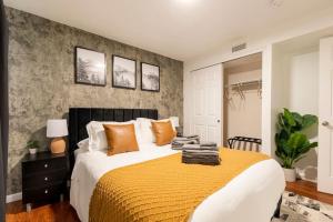 丹佛Adorable 2-Bedroom Modern Basement的一间卧室配有一张带橙色枕头的大床