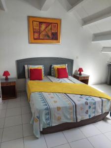 圣马丁岛Pelican的一间卧室配有一张大床,提供黄色和红色枕头