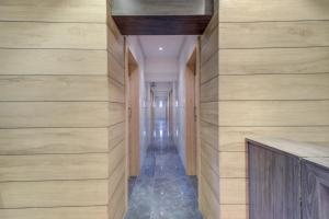 孟买Capital O 75709 Hotel Spring Residency的走廊设有木镶板墙和长长的走廊