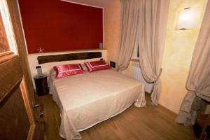 蒙特罗索阿尔马雷阿菲塔卡梅雷达切萨雷酒店的一间卧室配有一张带两个红色枕头的床