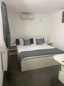 Ocna-MureşuluiCASA BELLA的一间卧室配有一张带紫色枕头的大床