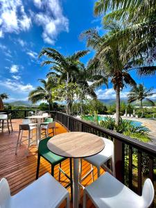 PaïtaRivland Resort的阳台配有桌椅,棕榈树