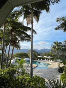 PaïtaRivland Resort的享有棕榈树度假村游泳池的景色