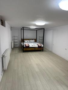 奥托佩尼Airport Confort House的一间卧室配有一张床,铺有木地板
