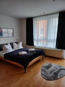 柏林商务公寓的一间卧室设有一张床和一个大窗户