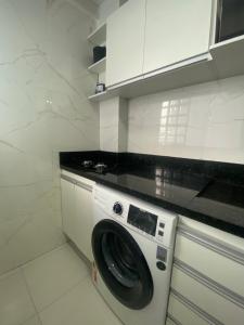 贝伦Flat completo no centro de Belém的厨房配有洗衣机,厨房配有白色橱柜