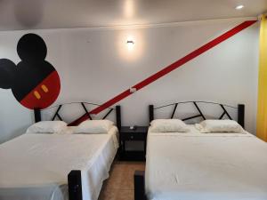 科马亚瓜Wally World Inn的墙上有红色条纹的房间里,有两张床