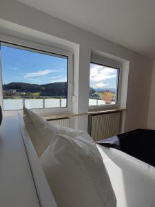 Ferienhaus Alpenblick的一间卧室设有一张床和两个窗户。