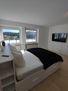 Ferienhaus Alpenblick的一间卧室配有一张带书桌和电视的床。