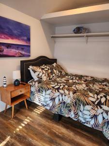 亨廷顿海滩Surf city House的一间卧室配有一张床,床头柜配有桌子