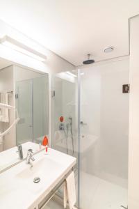 阿雷格里港Hotel Moov Porto Alegre的白色的浴室设有水槽和淋浴。