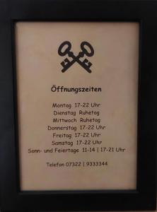 布伦茨河畔金根Brauereigasthof Schlüsselkeller的一张有两根交叉剪刀的标志的照片