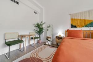 迈阿密海滩Tropics Hotel Miami Beach的卧室配有1张床、1张桌子和1把椅子