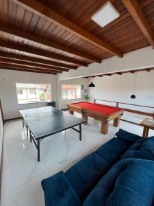 弗洛里亚诺波利斯Casa com Piscina temporada的客厅配有沙发和乒乓球桌