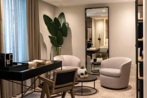 迈阿密海滩Nassau Suite South Beach, an All Suite Hotel的客房设有书桌、两把椅子和镜子