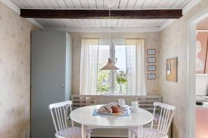 瑟尔沃斯堡Idylliskt hus med havsutsikt的一间配备有白色桌椅的用餐室