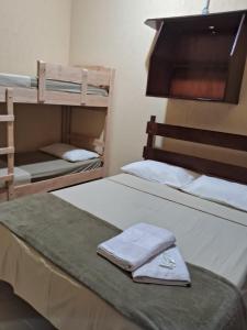 卡拉瓜塔图巴Pousada Sol e Lua的一间卧室配有两张双层床和毛巾