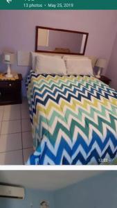金斯敦Cliff Apartment的一间卧室配有一张带五颜六色棉被的床