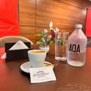科尔多瓦霍华德约翰逊加拿大套房酒店的一张桌子,上面放着一杯咖啡和一瓶水