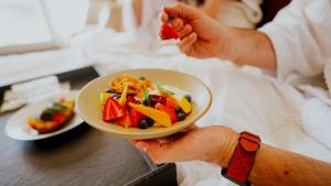 科尔多瓦霍华德约翰逊加拿大套房酒店的持有一盘带水果沙拉的食物的人