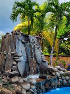 SuchitotoEl Tejado的一个带棕榈树和瀑布的喷泉