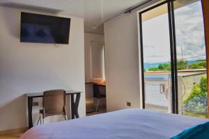 阿瓜奇卡Hotel El Sol Inn的一间卧室设有一张床和一个大窗户