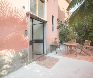 PioltelloVilla verdi vicinanze Milano centro的粉红色房子的大门,带桌子