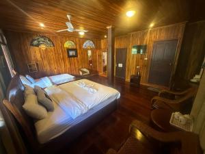 琅勃拉邦Khounphet Heritage House的木制客房内的一间卧室,配有一张床