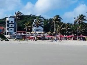 圣路易斯Edifício Ocean garden的海滩上设有遮阳伞、桌子和棕榈树