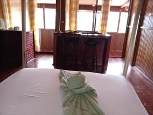 图里亚尔瓦Hotel Green Mountain的一张白色的床,上面有弓