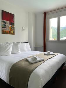 巴涅尔-德吕雄HOTEL & SPA GASQUET的一间卧室配有一张大床和毛巾