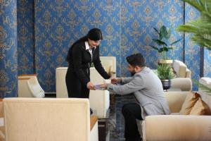 乔尔卢Safir Hotels Çorlu的女人在帮助一个在屋子里的男人