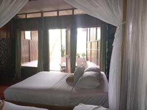 图里亚尔瓦Hotel Green Mountain的一间卧室配有一张带白色床单和窗户的床。