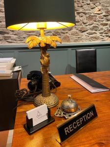 巴涅尔-德吕雄HOTEL & SPA GASQUET的桌子上的一盏灯,上面标有前台标志