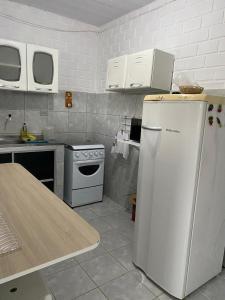 JaguaribeCasa Tina的厨房配有白色冰箱和炉灶。