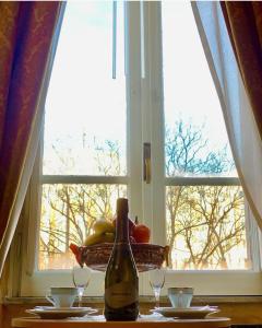 罗马教皇套房酒店的窗户前的桌子上坐着一瓶葡萄酒