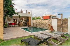 佩德拉斯港Magaral Casa de Praia的一个带游泳池和房子的后院