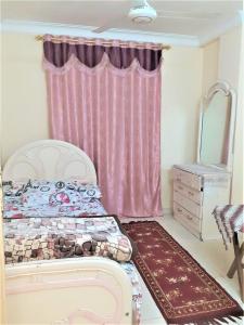 明亚Furnished apartment in Minya的一间卧室配有一张床和粉红色窗帘