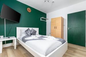 伦敦City Gate Guest House的一间卧室配有一张带绿色墙壁的床