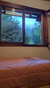 埃博森HOSTEL EL LIMON的卧室设有窗户、床和树木