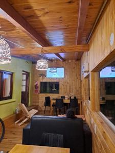 埃博森HOSTEL EL LIMON的用餐室设有木墙和桌椅